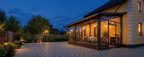 Terrazza accanto a una casa gialla con chiusure trasparenti flessibili e porta aperta