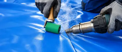 Saldatura di un telo blu in PVC con rullo pressore